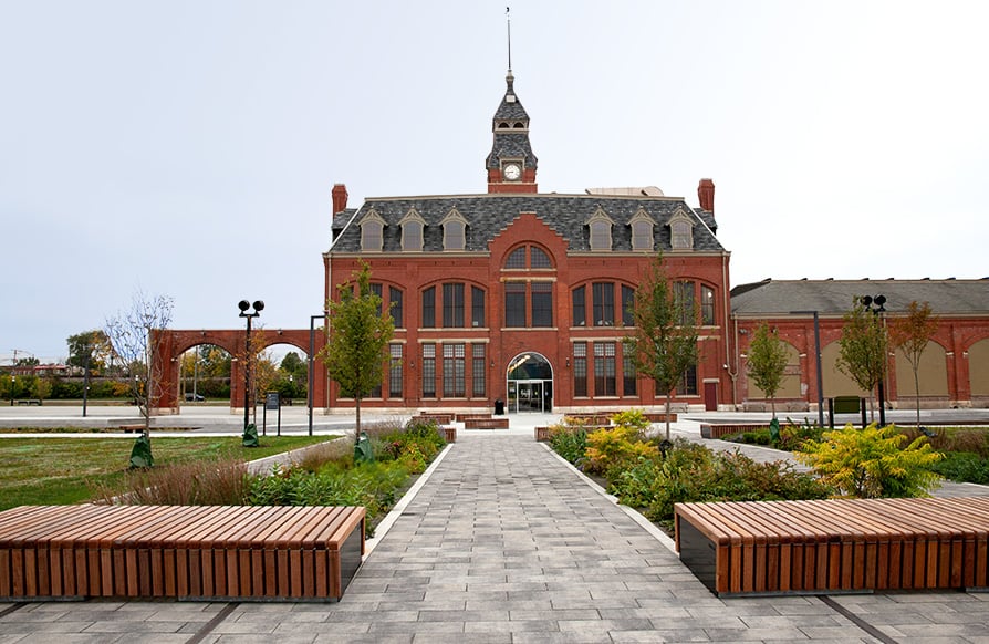 A view of the entrance of Pullman National Monument and the brick paths, benches, and landscaping around the building